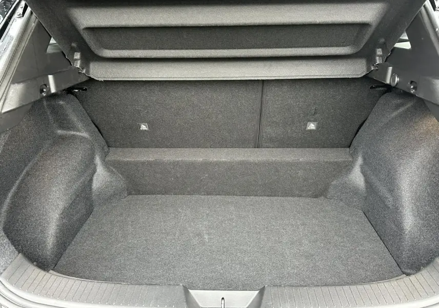 Coffre ouvert du Nissan Qashqai noir nacré, vue intérieure montrant l’espace de chargement vide et la moquette grise.