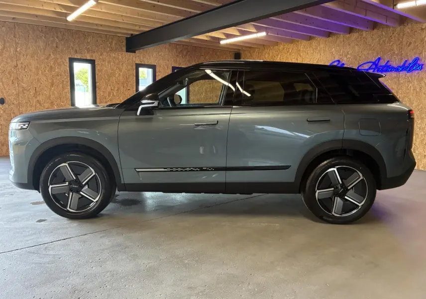 SUV JAECOO J7 gris olive avec toit noir vu de profil côté gauche, jantes alliage 19 pouces et vitres teintées.