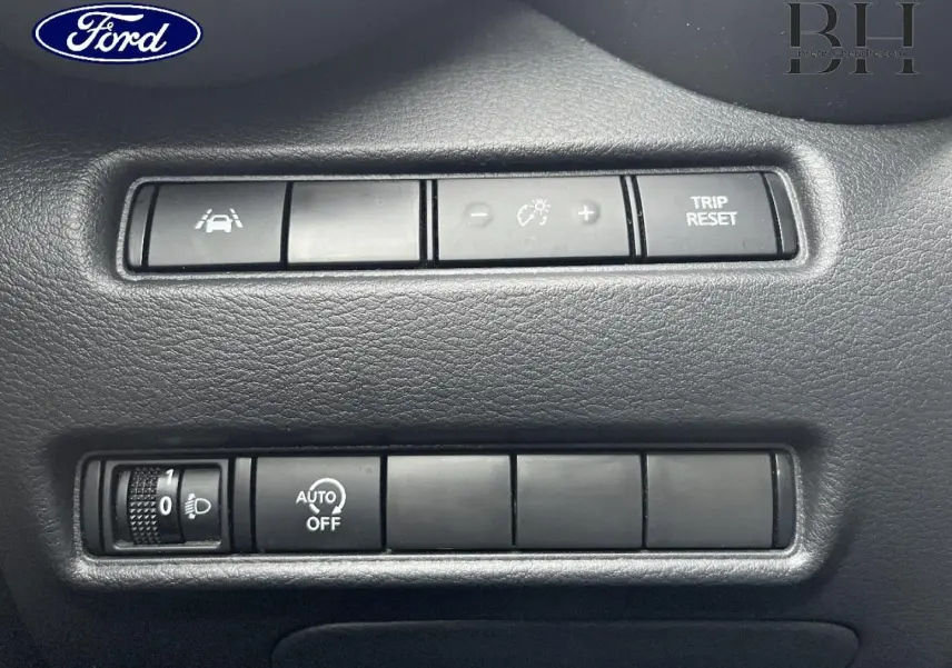 Panneau de commandes intérieures en plastique noir avec boutons de réglage d’éclairage et fonctions d’assistance, sans lien visible avec Nissan Juke.