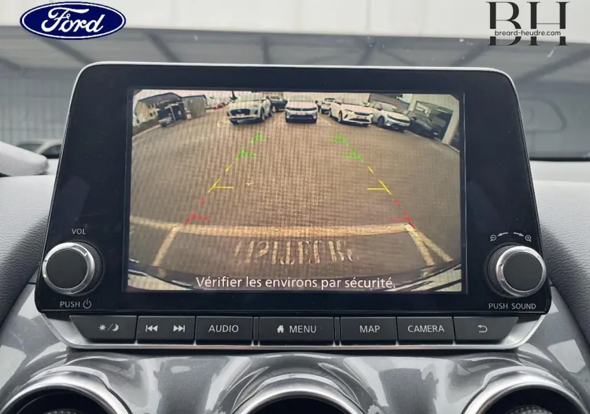 Écran tactile intérieur montrant la caméra de recul d'une Nissan Juke noir métallisé, vue frontale du tableau de bord.