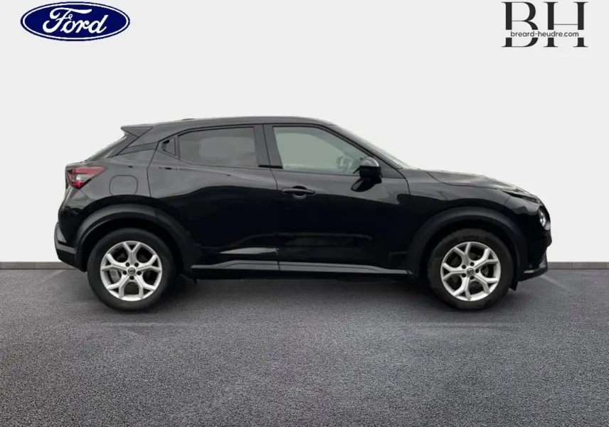 Profil droit d'un Nissan Juke noir métallisé 2020 avec jantes alliage et lignes compactes distinctives.