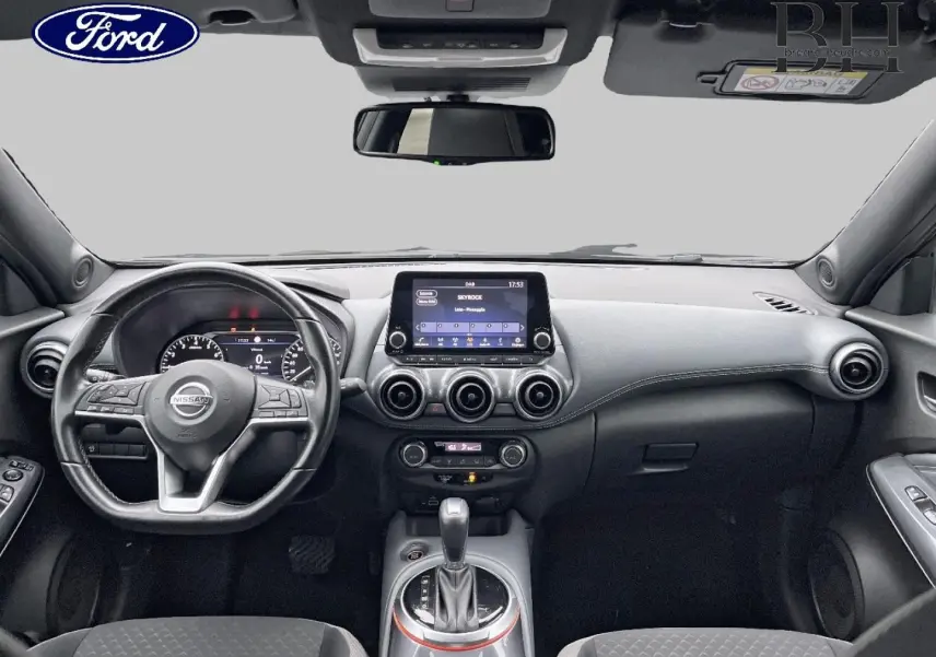 Vue intérieure avant du Nissan Juke noir métallisé 2020, avec tableau de bord moderne et écran tactile central.