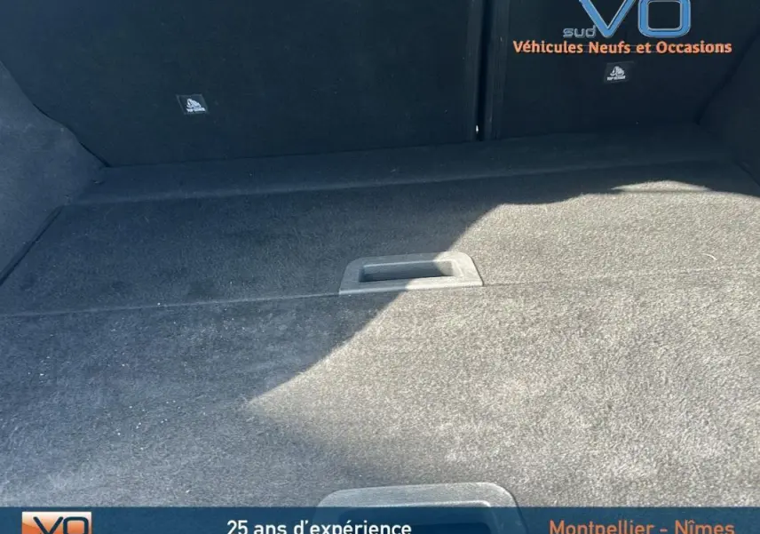 Coffre spacieux et propre du Renault Kadjar bleu foncé TCe 140 Business, vue intérieure arrière sans chargement visible.