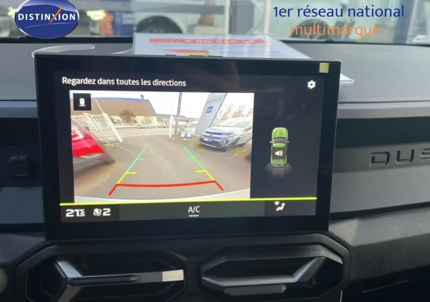 Écran central montrant la caméra de recul du Dacia Duster 1.6 Hybrid blanc glacier, tableau de bord noir avec logo Duster.