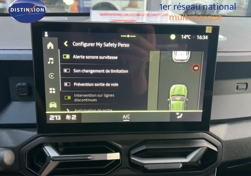 Écran tactile central du Dacia Duster blanc glacier 2025 montrant les options d’aide à la conduite et la climatisation.