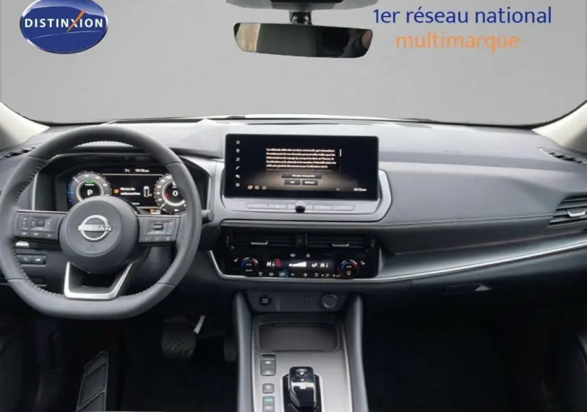 Vue intérieure frontale du tableau de bord noir du Nissan Qashqai blanc 2025 avec écran tactile et volant cuir.