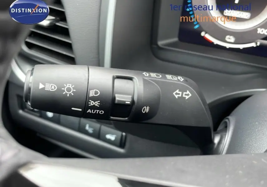 Gros plan sur la commande des feux et clignotants à gauche du volant du Nissan Qashqai blanc 2025.