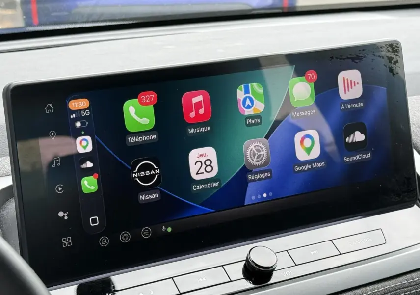 Écran tactile central du Nissan Qashqai 2025 affichant Apple CarPlay avec icônes colorées, vue intérieure rapprochée.