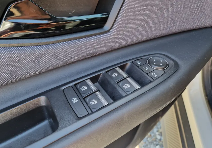 Gros plan sur la commande des vitres et rétroviseurs côté gauche de la porte d’une Renault R5 E-TECH blanc nacré/noir.