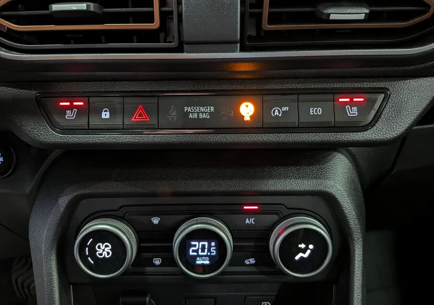 Tableau de bord intérieur de la Dacia Sandero Stepway 2025, affichage climatisation digitale à 20,5°C et boutons de sièges chauffants allumés.