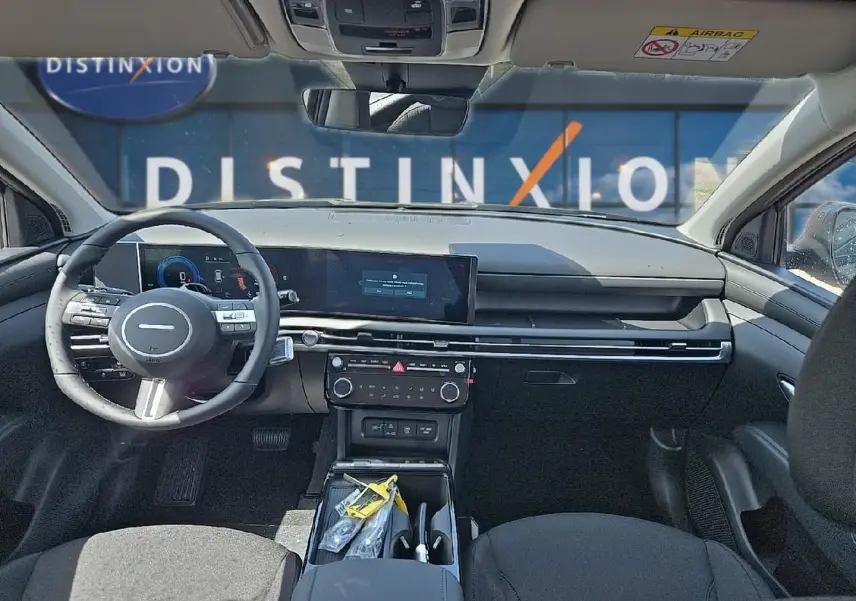 Vue intérieure avant du Hyundai Tucson 2026 noir, avec tableau de bord numérique et volant multifonction cuir.