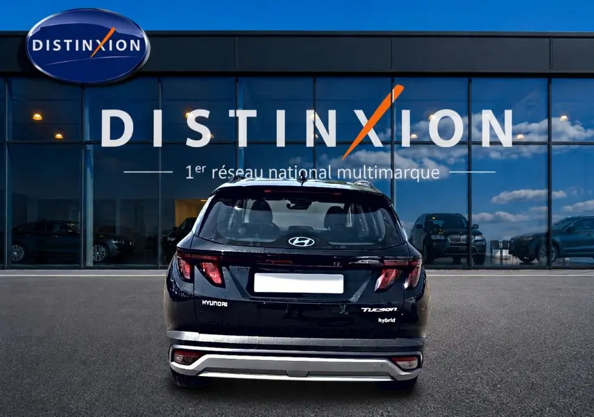 Vue arrière d'un Hyundai Tucson noir hybride 2026, avec logo et feux LED distinctifs, devant une vitrine Distinxion.