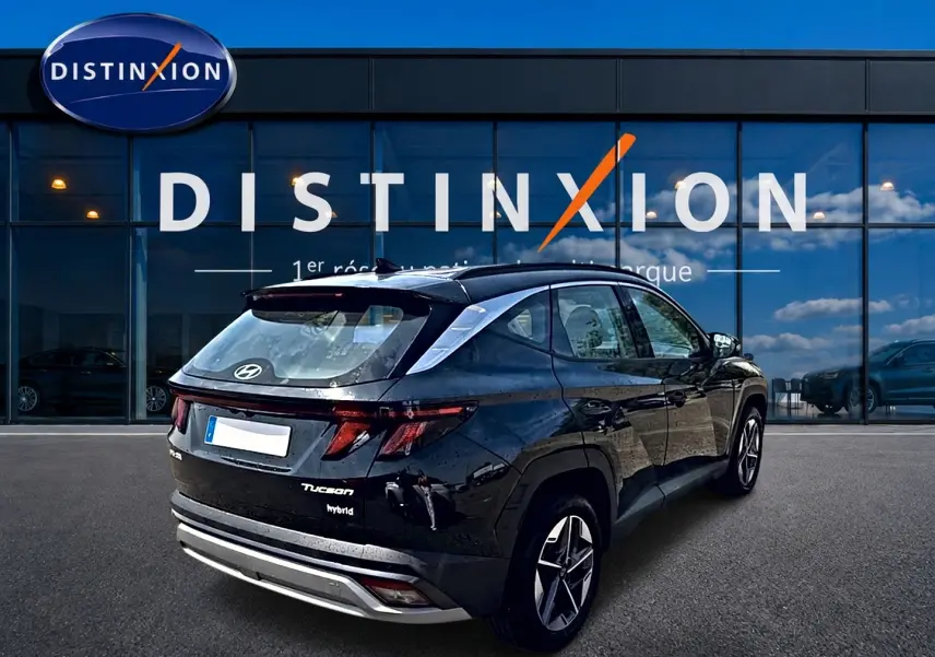 Vue 3/4 arrière droite d'un Hyundai Tucson noir hybride 2026 avec jantes alu et feux LED distinctifs.
