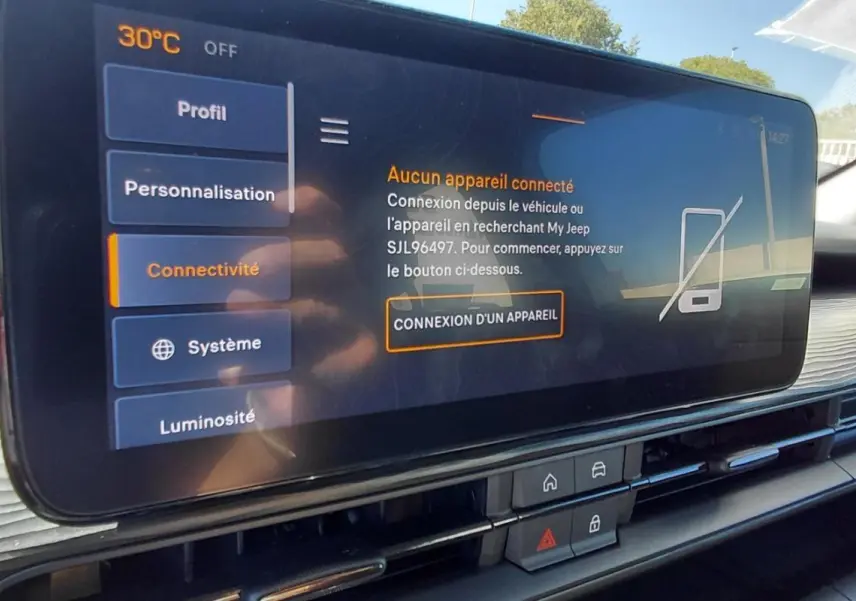 Écran tactile central du tableau de bord du Jeep Avenger blanc 2025, avec menu connectivité et haut-parleur JBL visible.