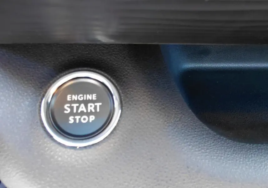 Bouton start/stop moteur en gros plan sur le tableau de bord du Jeep Avenger blanc 2025, version Altitude.