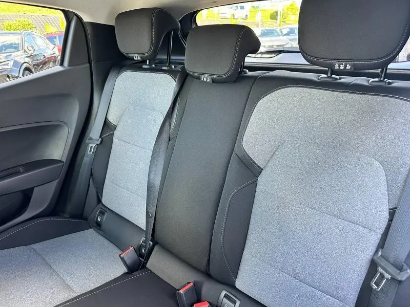 Vue intérieure arrière de la Renault Clio 2025, sièges en textile gris motif 3D avec ceintures de sécurité noires.