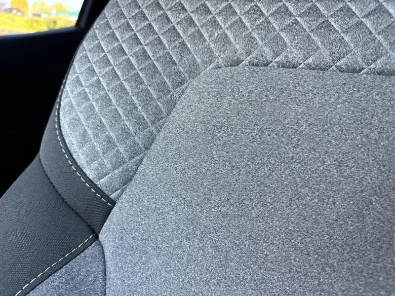 Gros plan sur le tissu gris à motif 3D du siège avant de la Renault Clio 2025, version Evolution.