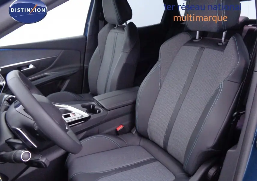 Vue intérieure côté conducteur du Peugeot 3008 2023 bleu Célèbes Métal, sièges tissu et cuir noir avec surpiqûres bleues.