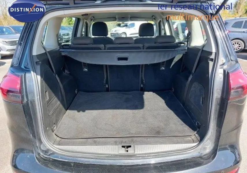 Coffre ouvert en vue arrière d’une Opel Zafira noire métal 2017, montrant l’espace de chargement et la banquette arrière.