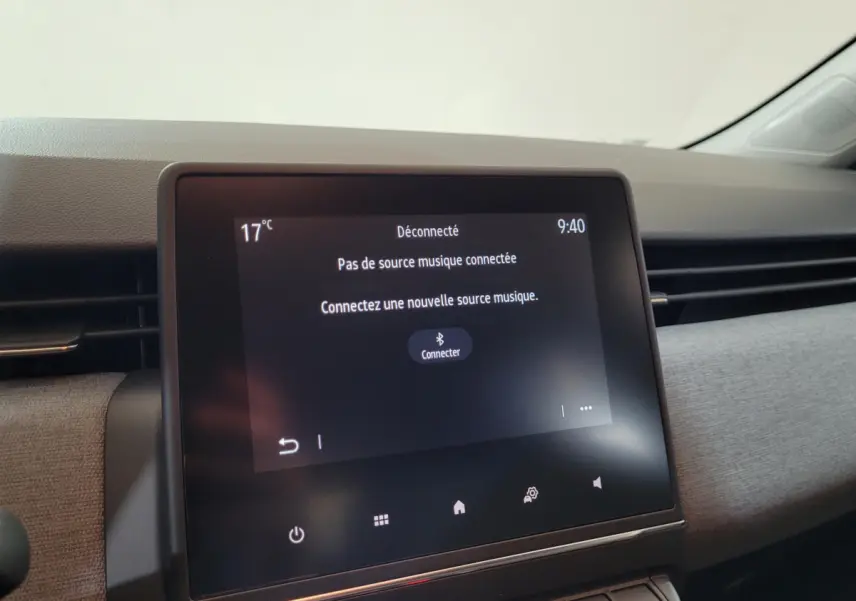 Écran tactile central de la Renault Clio bleu 2025 affichant une invitation à connecter une source musicale.