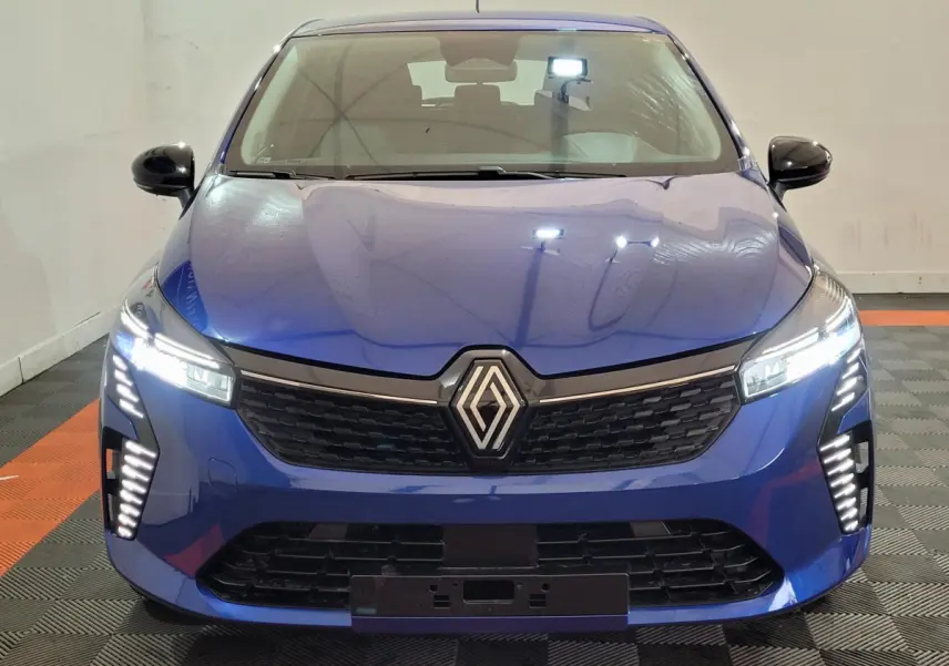 Vue frontale d'une Renault Clio Evolution Blue dCi 100 2025 en bleu avec phares LED et calandre noire distinctive.