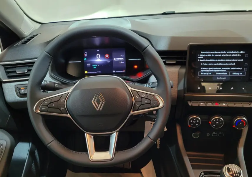 Vue intérieure centrée sur le volant cuir de la Renault Clio 2025 avec tableau de bord digital et écran tactile.