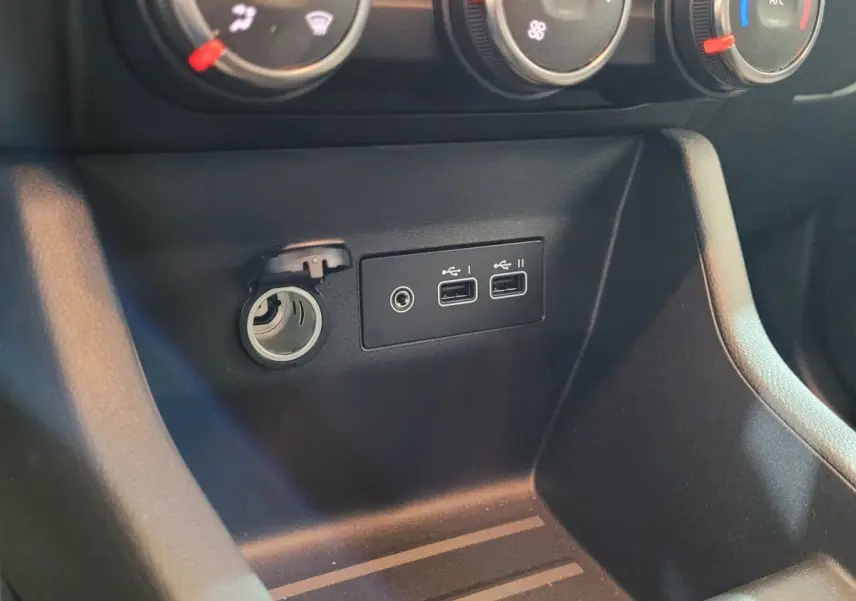 Prise 12V et deux ports USB noirs sous les commandes de climatisation dans l'habitacle d'une Renault Clio 2025.