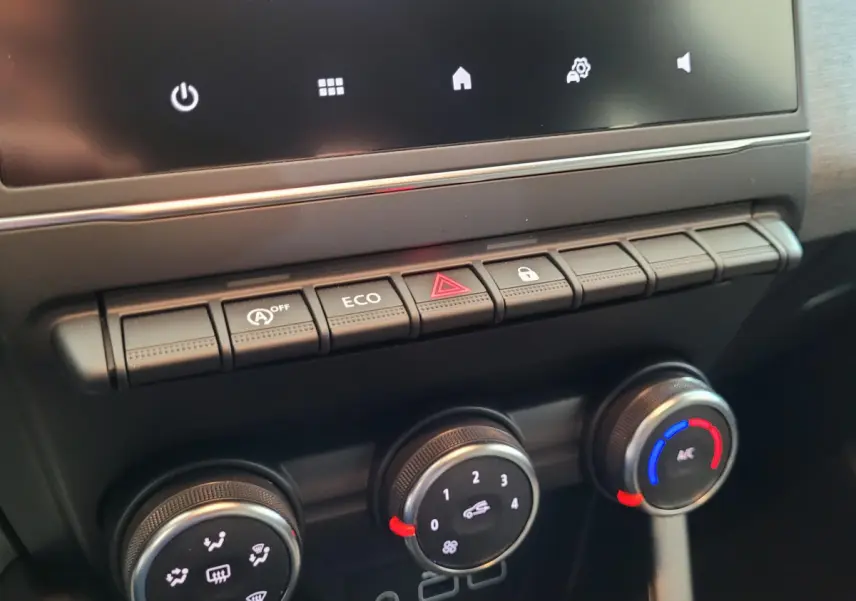 Gros plan sur les commandes de climatisation et boutons centraux du tableau de bord de la Renault Clio bleu Evolution 2025.