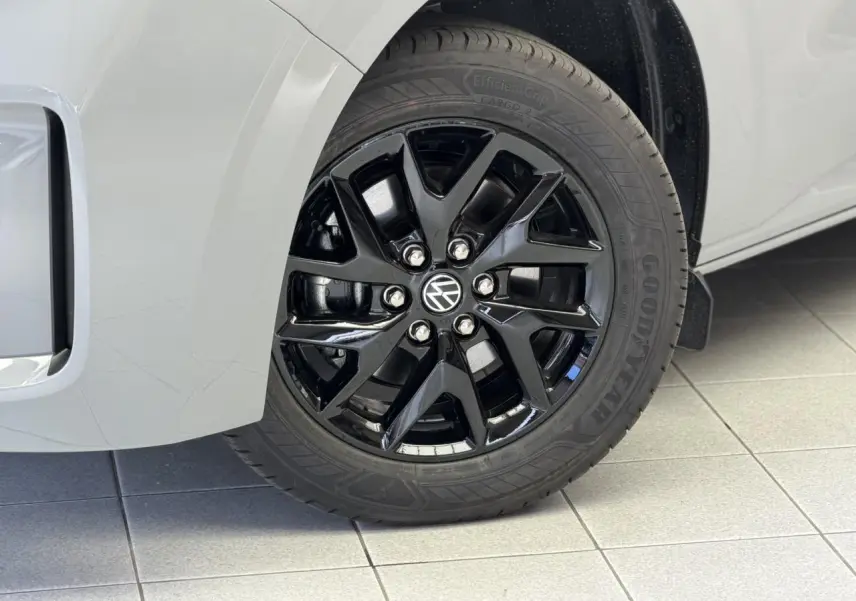 Gros plan sur la jante avant droite noire brillant Le Mans du Volkswagen Transporter T7 gris Stone.