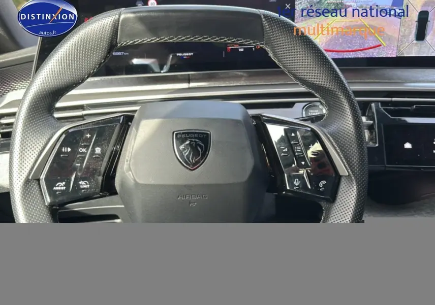 Vue rapprochée du volant cuir noir perforé du Peugeot 3008 gris Artense avec affichage numérique et commandes intégrées.