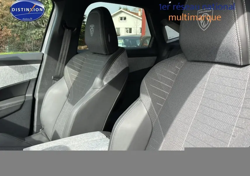 Vue rapprochée des sièges avant gris artense du Peugeot 3008 1.2 hybrid 145 GT avec logo Peugeot brodé sur les appuis-tête.