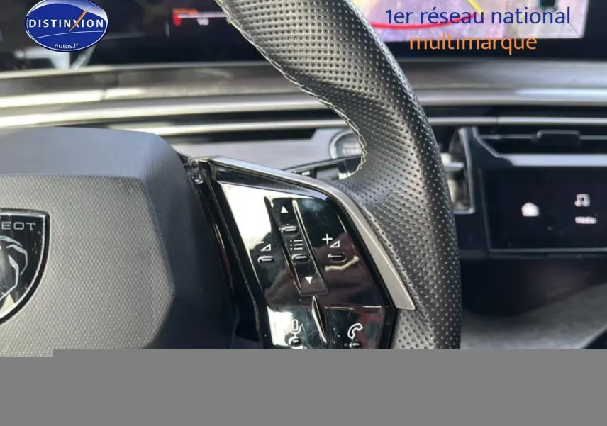 Gros plan sur le volant cuir perforé côté gauche du Peugeot 3008 gris Artense avec commandes multifonctions visibles.