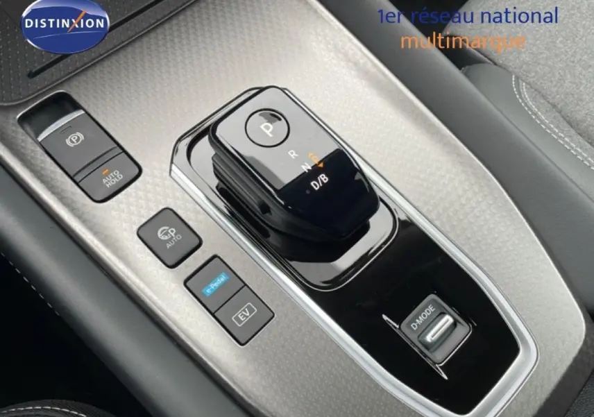 Gros plan sur la console centrale noire du Nissan Qashqai 2025 avec sélecteur de boîte auto et boutons de mode de conduite.