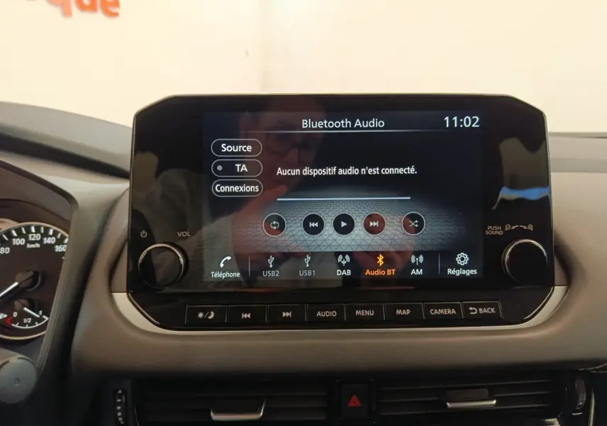 Écran tactile central du tableau de bord du Nissan Qashqai gris foncé, affichant le menu audio Bluetooth.