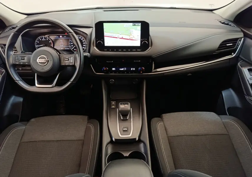 Vue intérieure avant du Nissan Qashqai 1.3 MHEV 2022, tableau de bord avec écran tactile et volant multifonctions noir.