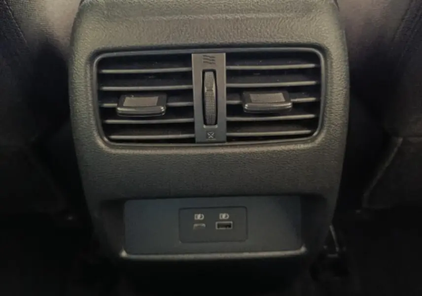 Vue rapprochée de la console arrière noire du Nissan Qashqai 2022 avec aérateurs et ports USB visibles.