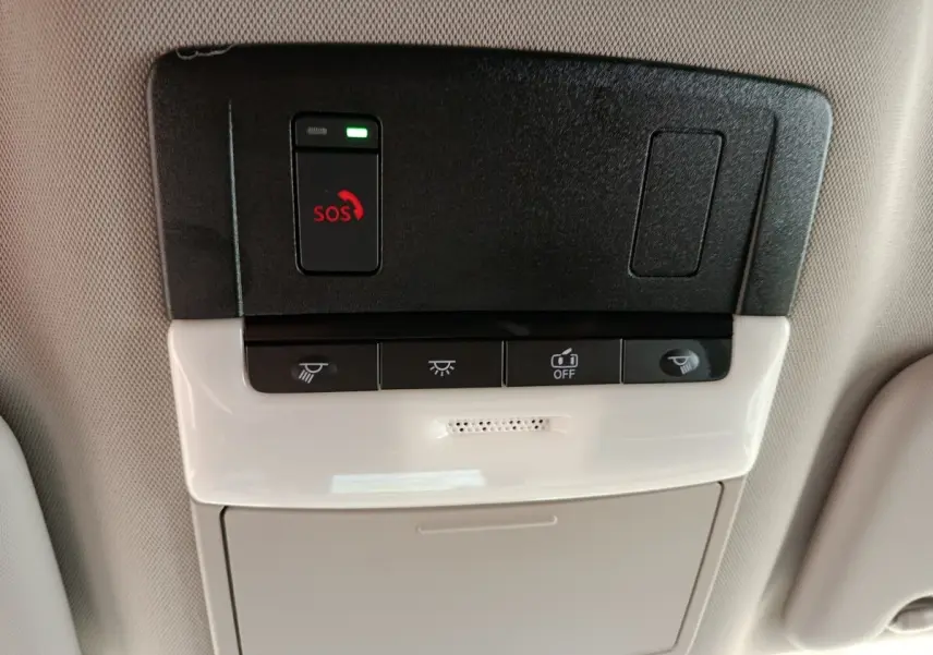 Vue en gros plan du panneau de commande au plafond intérieur du Nissan Qashqai gris foncé, avec bouton SOS et commandes d’éclairage.