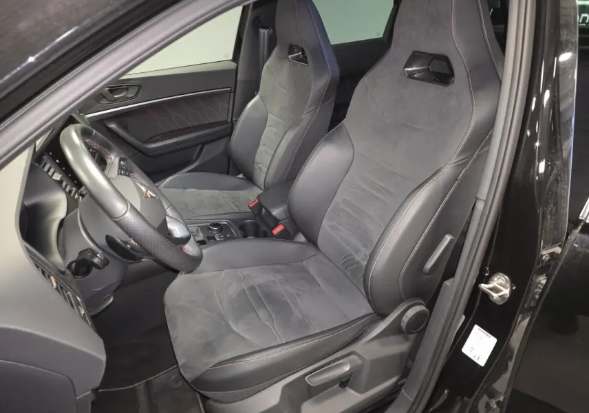 Vue intérieure côté conducteur du CUPRA Ateca 2024 noir, sièges baquets en suédine noire avec surpiqûres copper.