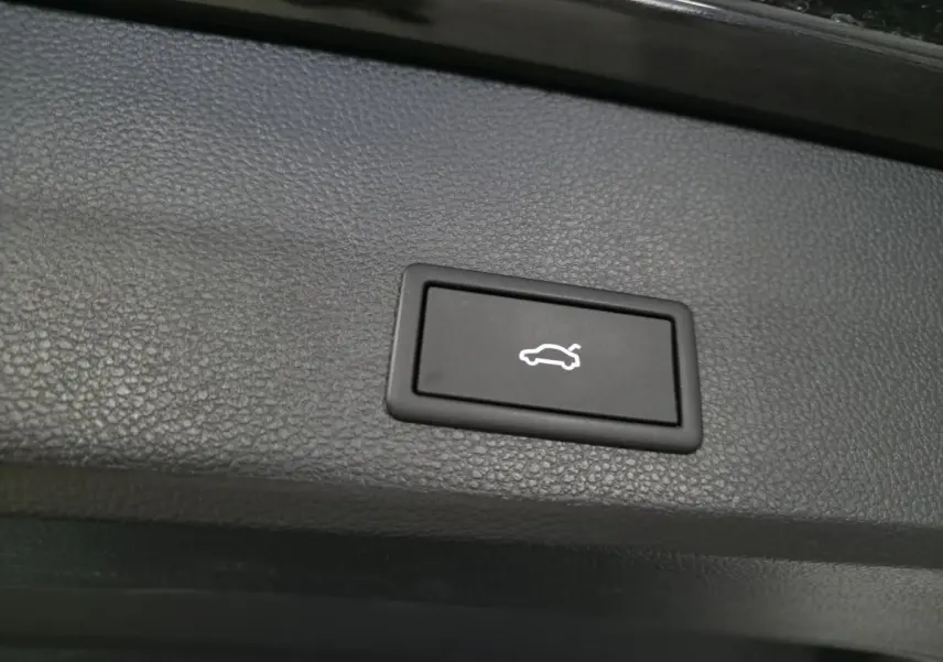 Bouton noir d'ouverture électrique du hayon sur panneau intérieur d'un CUPRA Ateca 2024, finition noire.