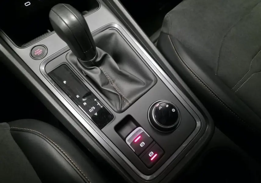Vue rapprochée de la console centrale noire du CUPRA Ateca 2024 avec levier de vitesse automatique et molette de sélection.