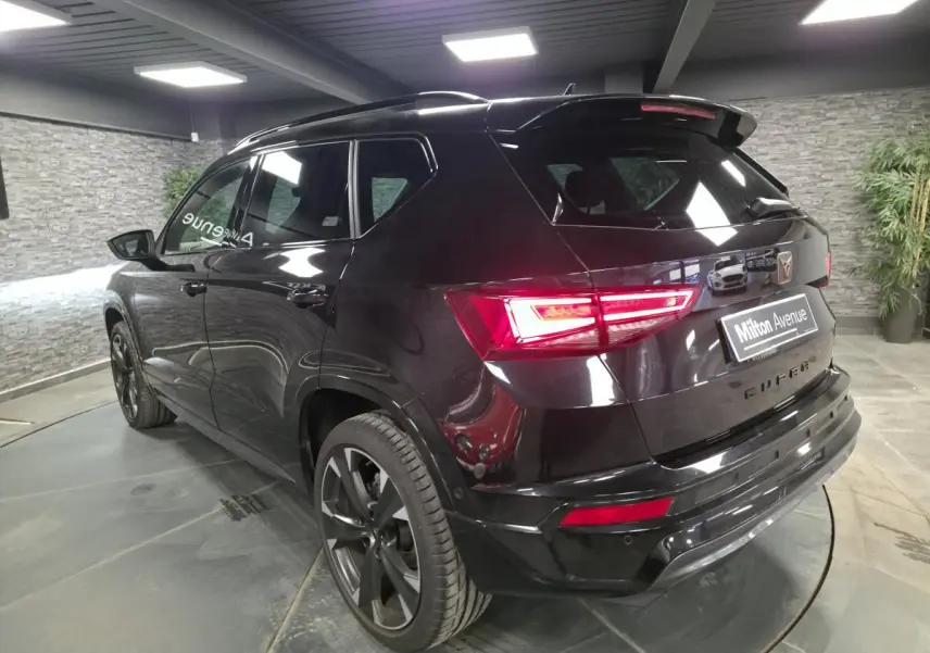 Vue 3/4 arrière droite d’un CUPRA Ateca noir avec feux LED et jantes alliage 19 pouces dans un showroom.