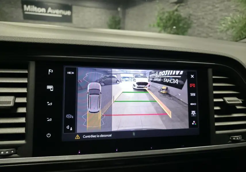 Écran de caméra de recul montrant l’arrière d’une CUPRA Ateca noire avec lignes de guidage colorées.