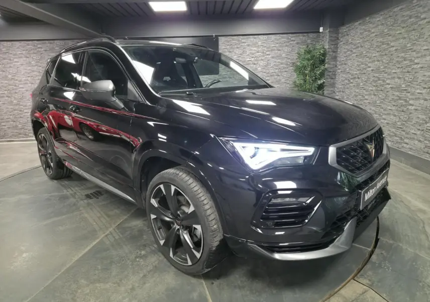 Vue 3/4 avant droite d'une CUPRA Ateca 2024 noire avec jantes alliage noires et signature lumineuse LED distinctive.