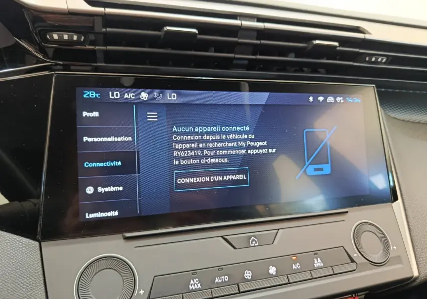 Écran tactile central affichant le menu connectivité dans l’habitacle d’une Peugeot 308 blanche, vue de face rapprochée.