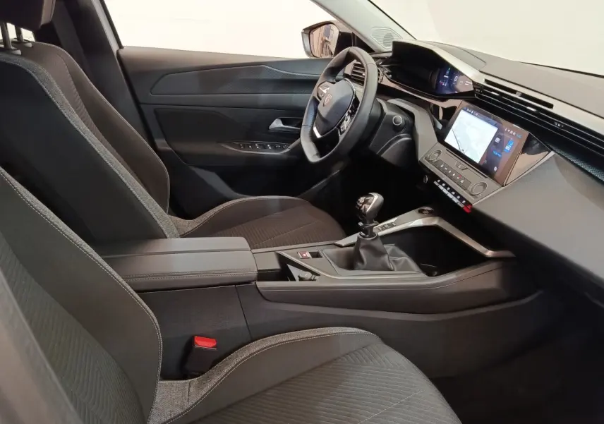 Intérieur de la Peugeot 308 2024 vue côté conducteur, sièges noirs, tableau de bord avec écran tactile et volant cuir.