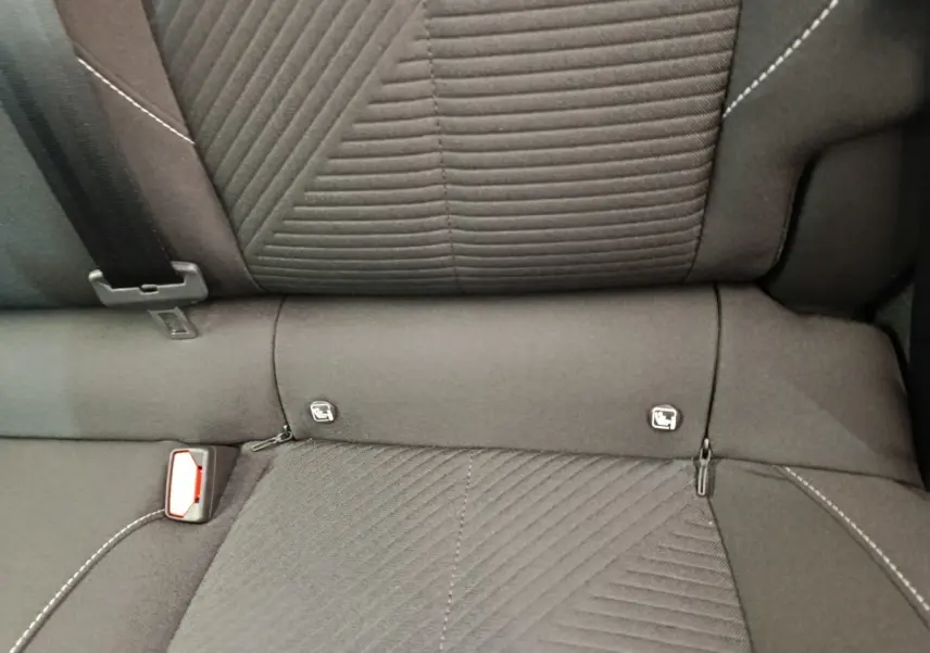 Gros plan sur la banquette arrière noire de la Peugeot 308 2024, montrant les fixations Isofix et la ceinture de sécurité.