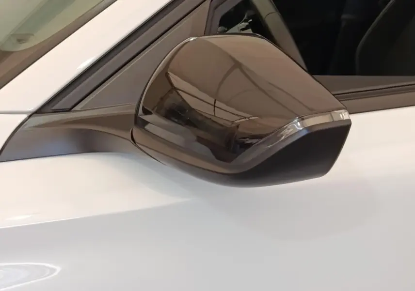 Rétroviseur noir en gros plan côté gauche d'une Peugeot 308 blanche 2024 Active Pack essence.