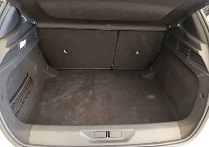 Coffre ouvert de Peugeot 308 blanc, vue intérieure montrant l'espace de chargement et la banquette arrière rabattable.