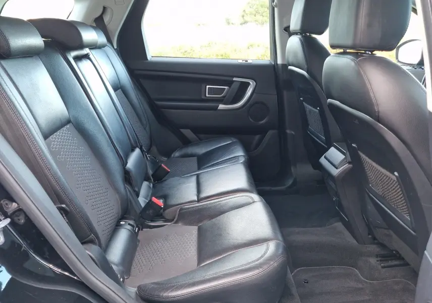 Vue 3/4 arrière droite d'un Land Rover Discovery Sport noir de 2017, avec logo distinctif et finition SE A visible.