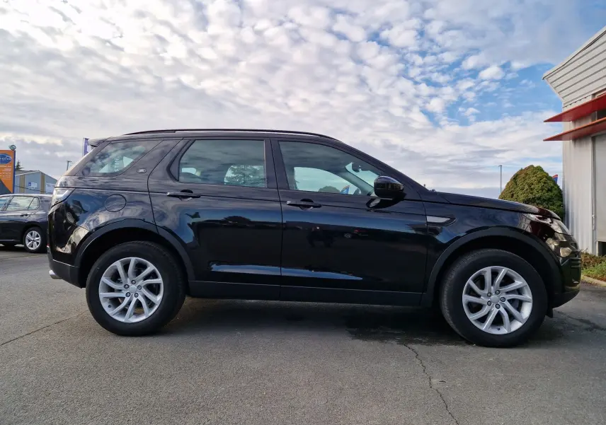 Vue intérieure du Land Rover Discovery Sport Mark II 2017, tableau de bord et volant en cuir noir avec commandes intégrées.